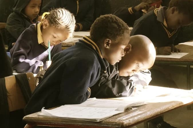 Enfants dans une salle de classe avec leurs cahiers